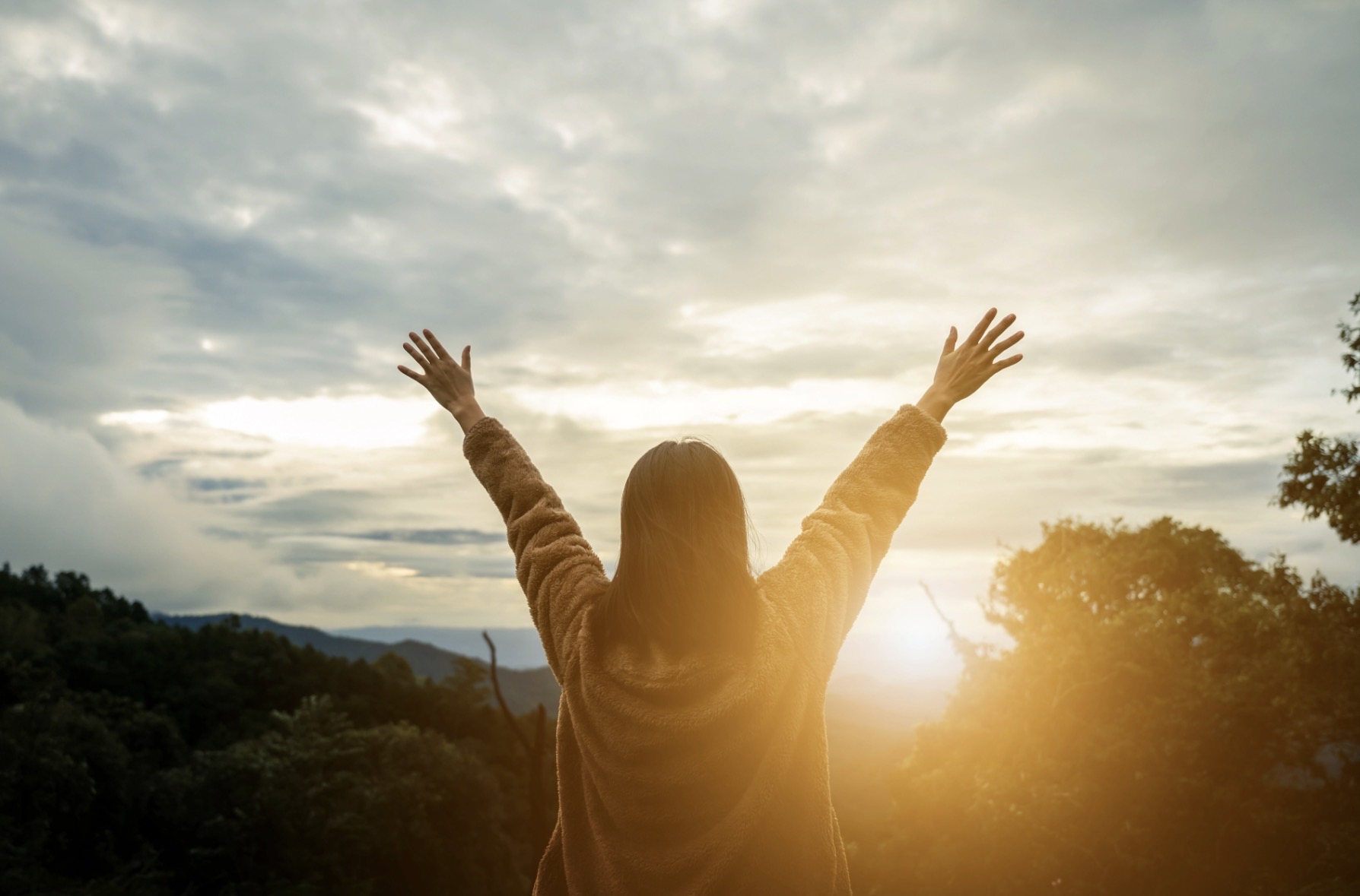 Persona sosteniendo una figura sonriente al atardecer como símbolo de bienestar emocional